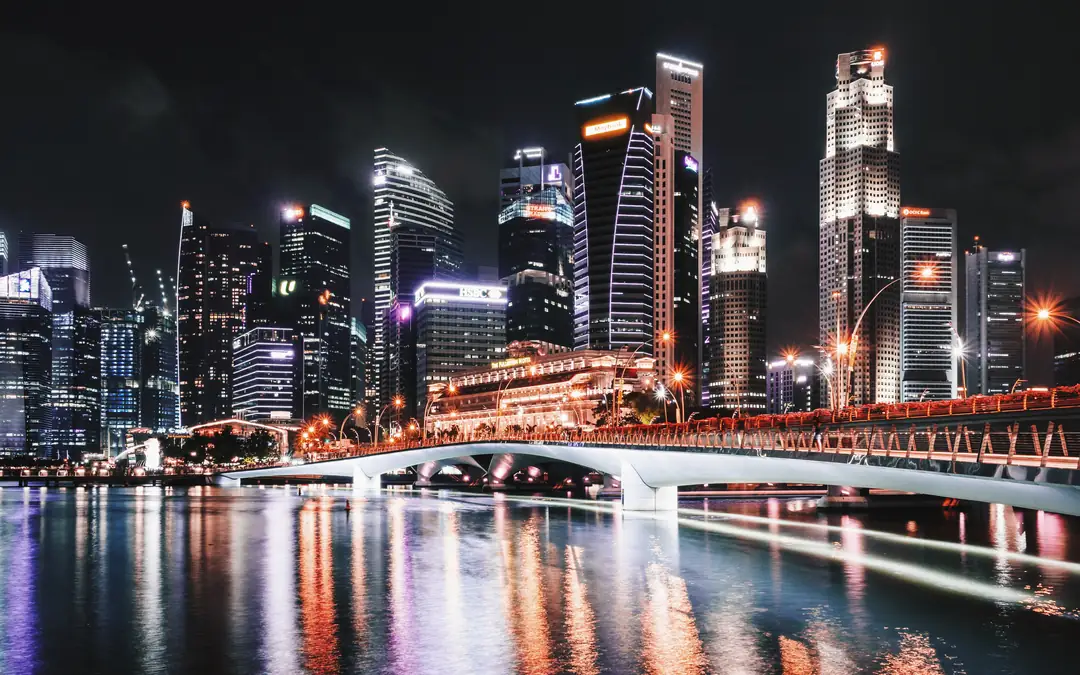 Singapore skyline and Jubilee Bridge lit up at night over Marina Bay
