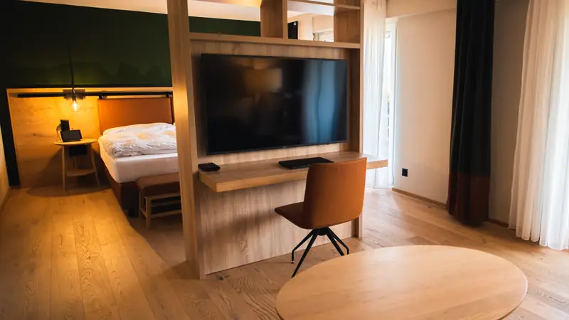 Hotel room with a work desk, chair and wall-mounted TV