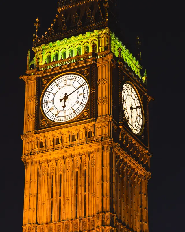 Elizabeth Tower clock face lit up at night in London
