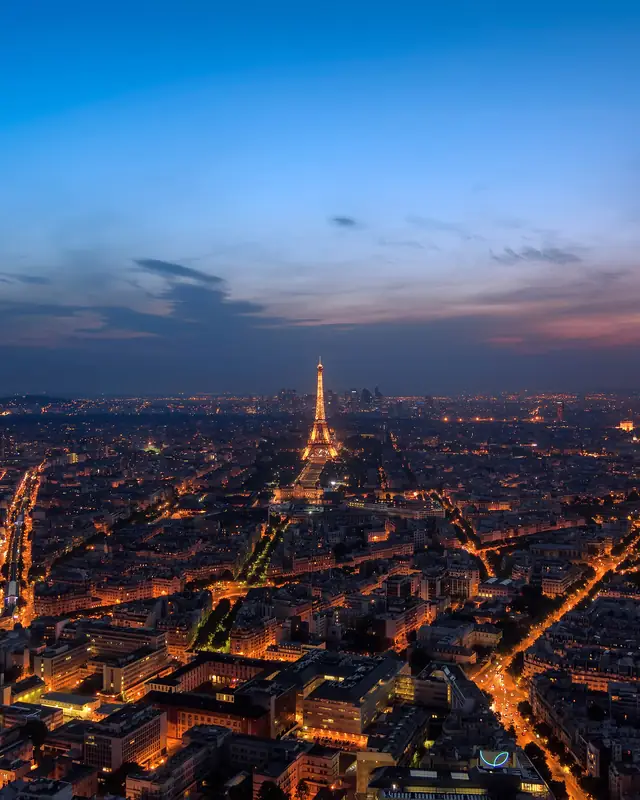 Paris at dusk from above, with the Eiffel Tower lit up
