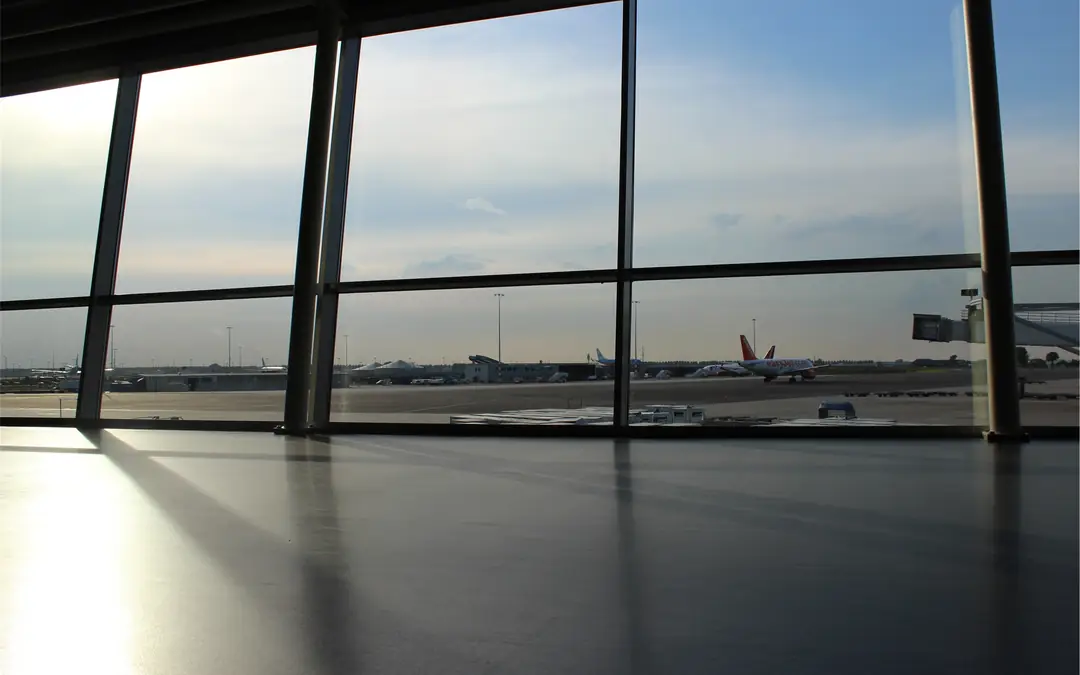 Floor-to-ceiling terminal windows looking out over the airport apron