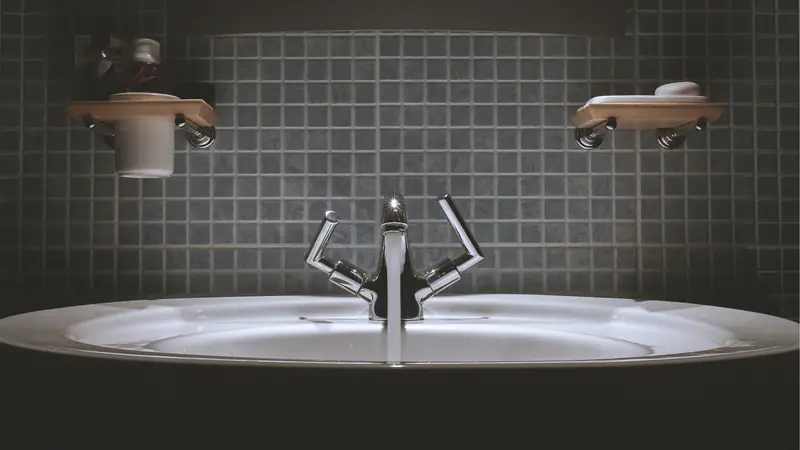 Modern washroom with a basin, mixer tap and dark tiles
